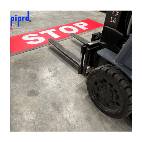 Large stop floor sign spanning warehouse aisle for forklift traffic safety