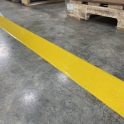 Mighty Tac texture floor tape adhered to warehouse floor in front of pallet.