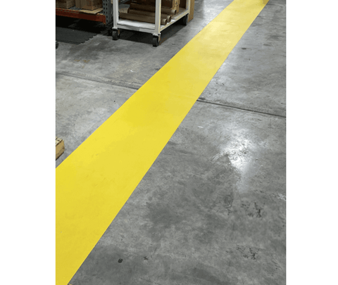 Yellow adhesive walkway path on warehouse floor